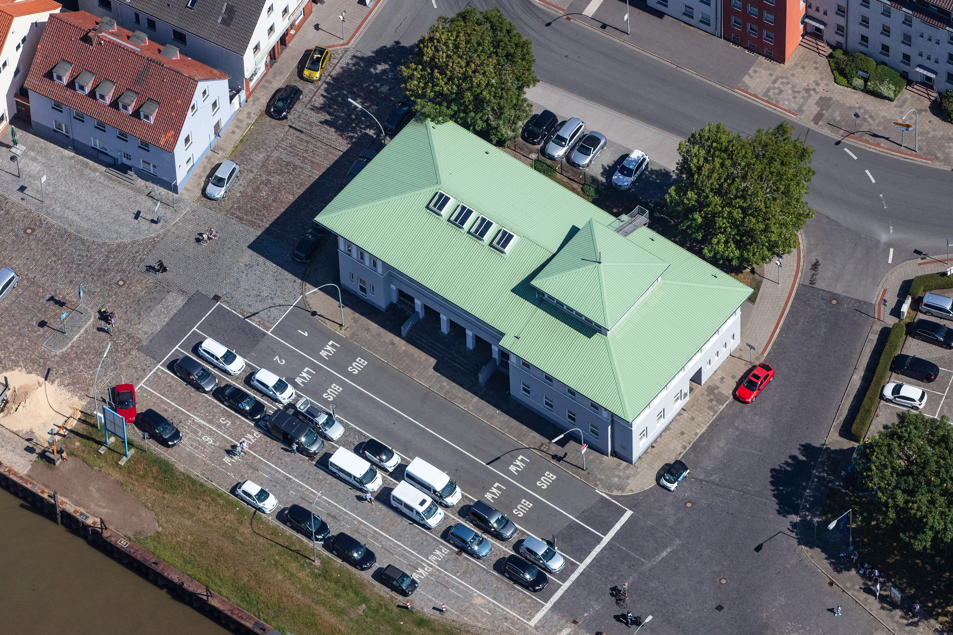 Auf diesem Bild ist das Fährhaus Bremerhaven zu sehen. Es hat ein helles, minzgrünes Dach, das sehr auffällig ist.